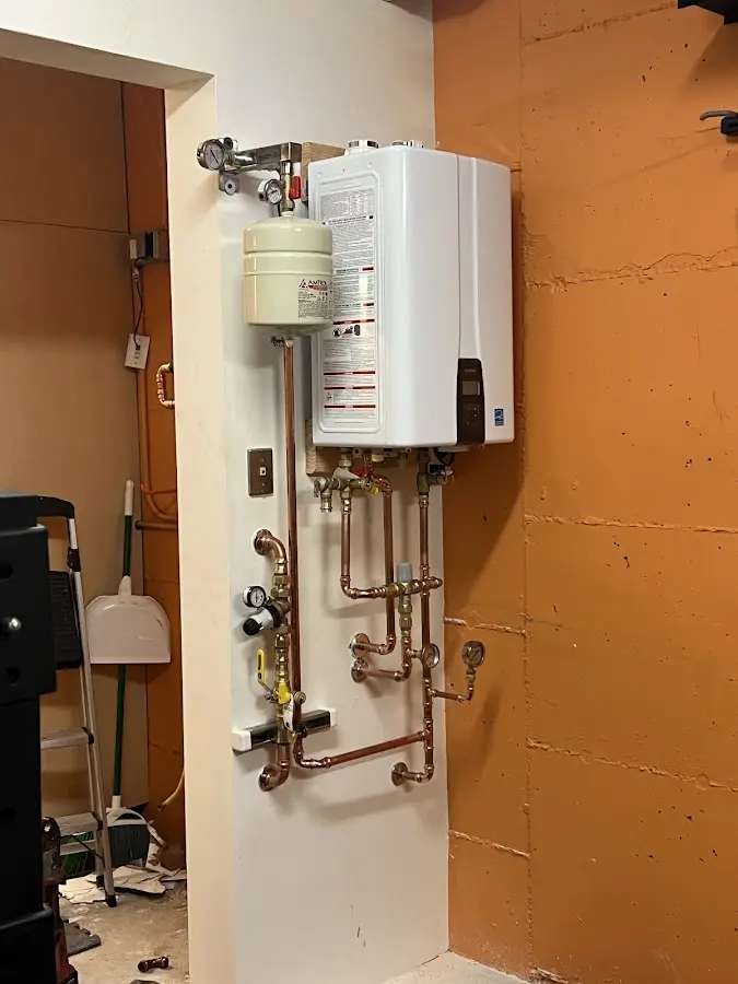 Plumbing technician inspecting water heater connections in Shelbyville